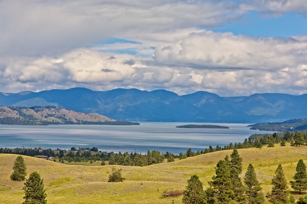 A scenic view of Flathead Lake from Polson, Montana with clouds over the mountains in the background