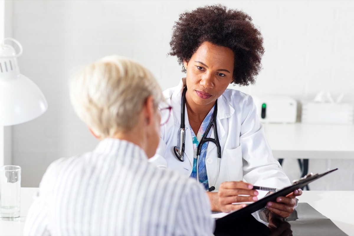 Mature woman with her doctor in ambulance talking about healthcare