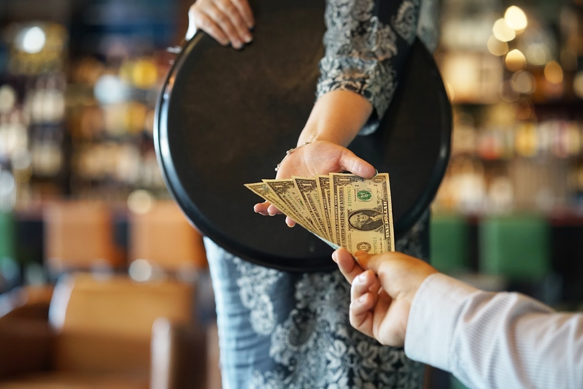 Customer Giving Waitress a tip with One Dollar Bills