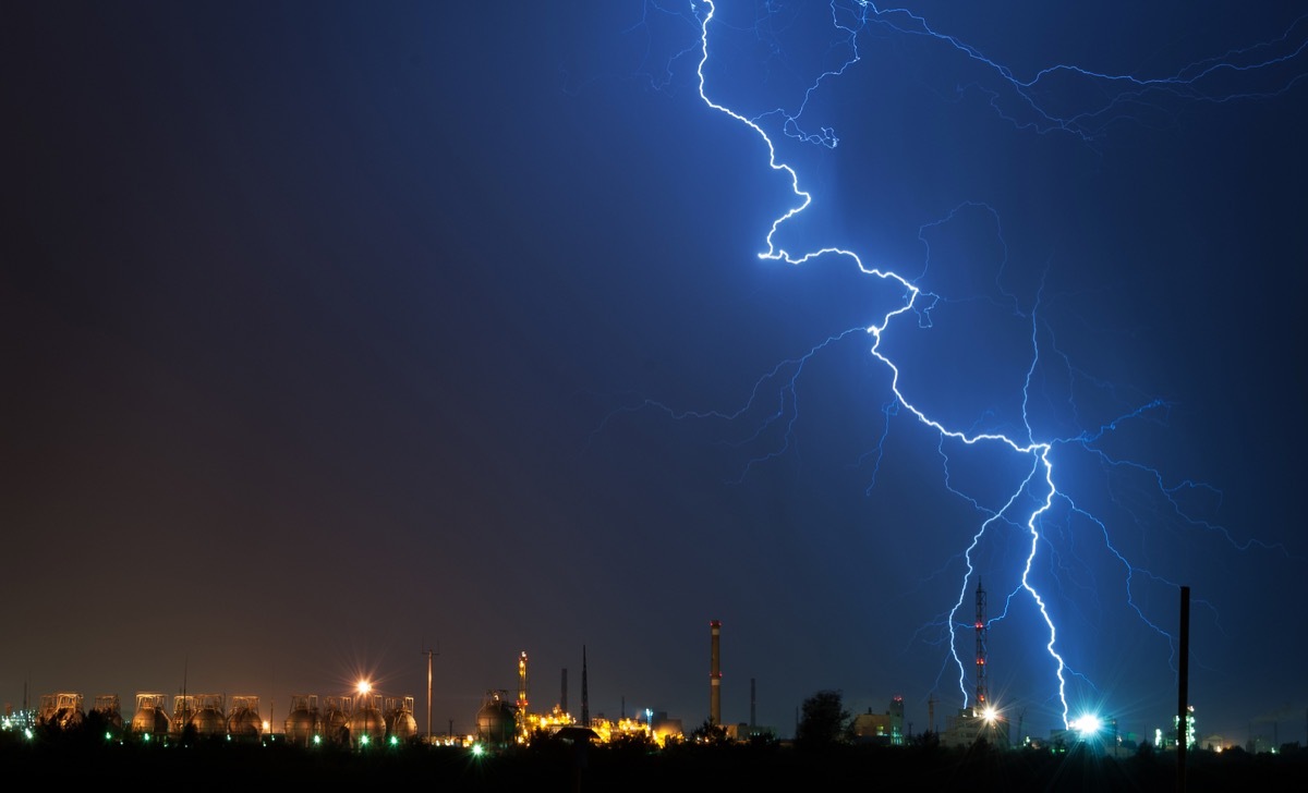 Flashes of lightning in the night sky. Lightning strike. Lightning near the factory. Night sky. Storm cloud. A flash of lightning. Industrial landscape before the storm - Image