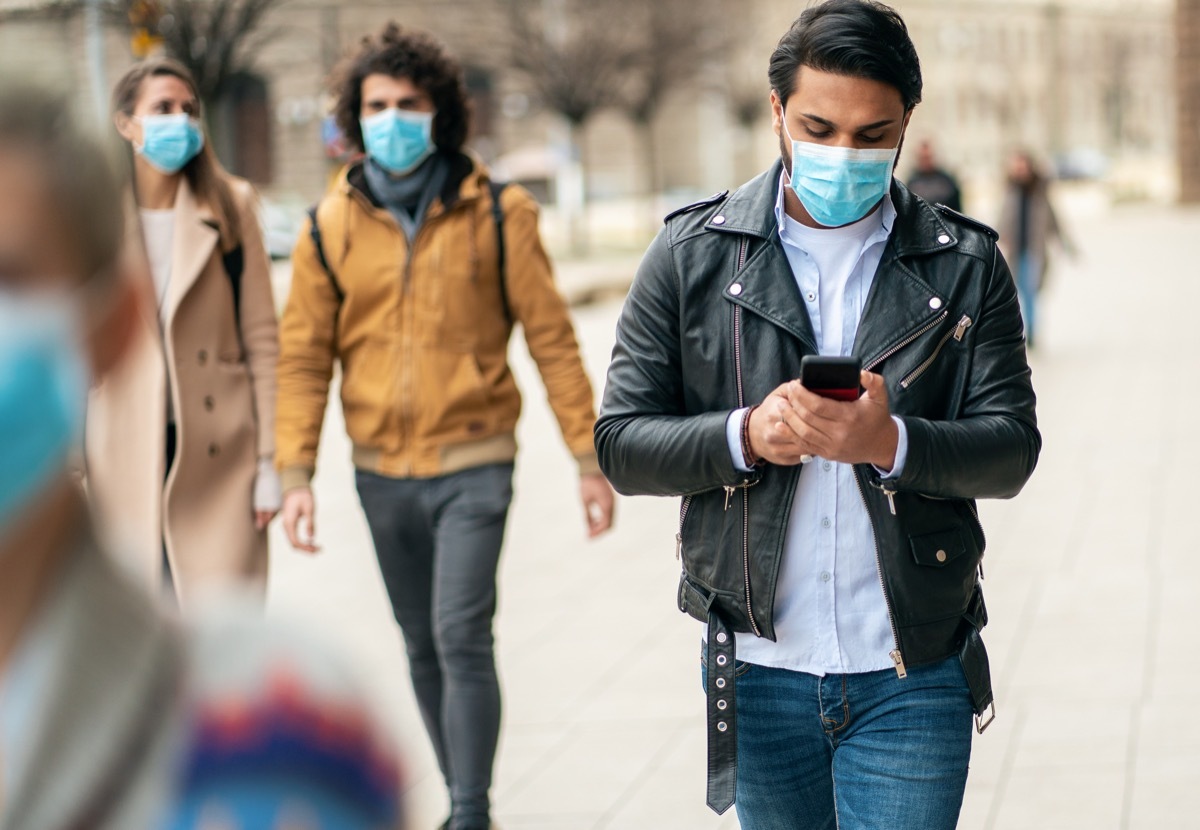 two men wearing masks on the street