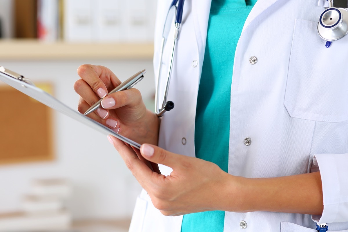 female doctor holding pen and clipboard