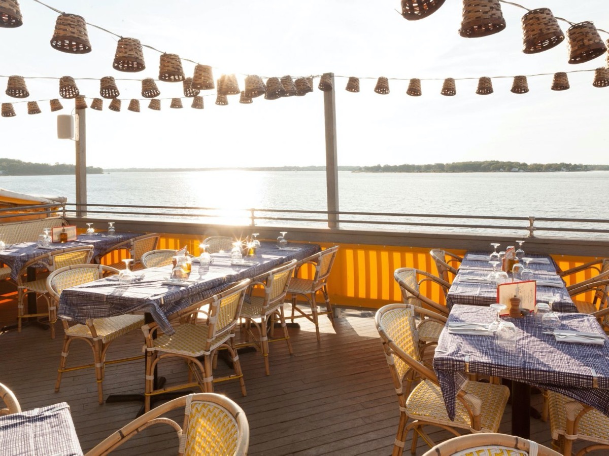 waterfront deck with tables and hanging lights