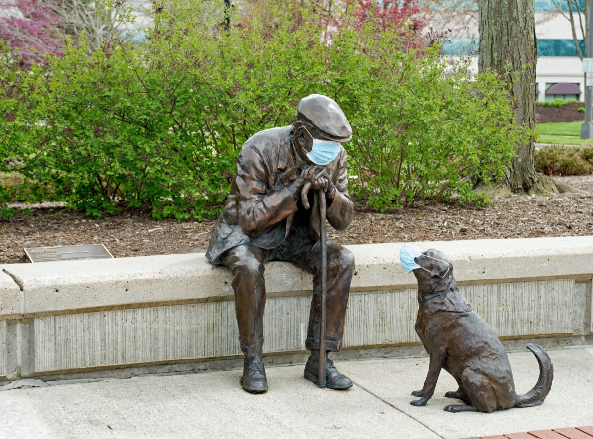 Bronze sculpture Old Man and His Dog by Glenna Goodacre seen here in Lincoln Park with PPE masks during the COVID-19 pandemic as part of mandate of social responsibility