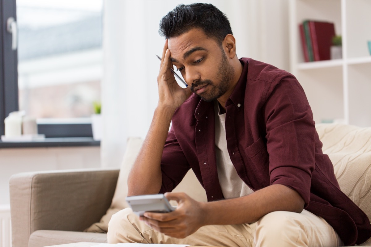 Man using calculator foggy confused