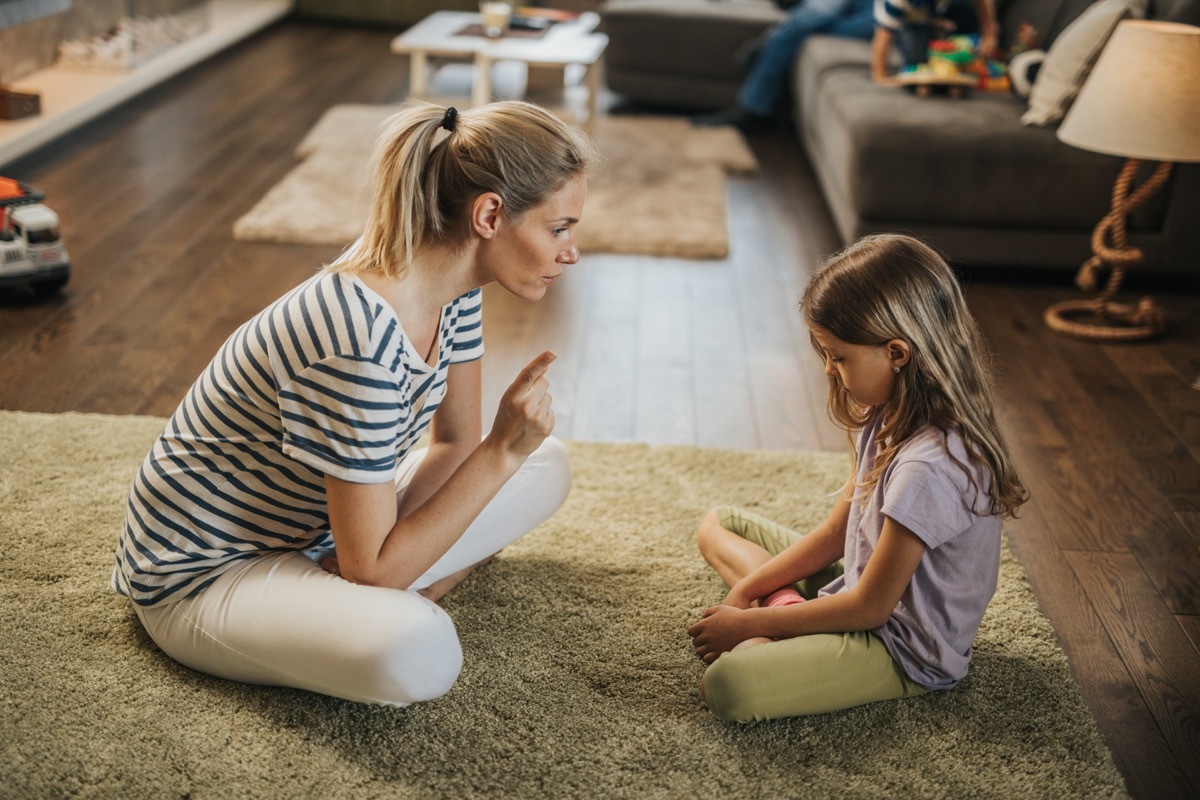 parent getting on to her kid in living room