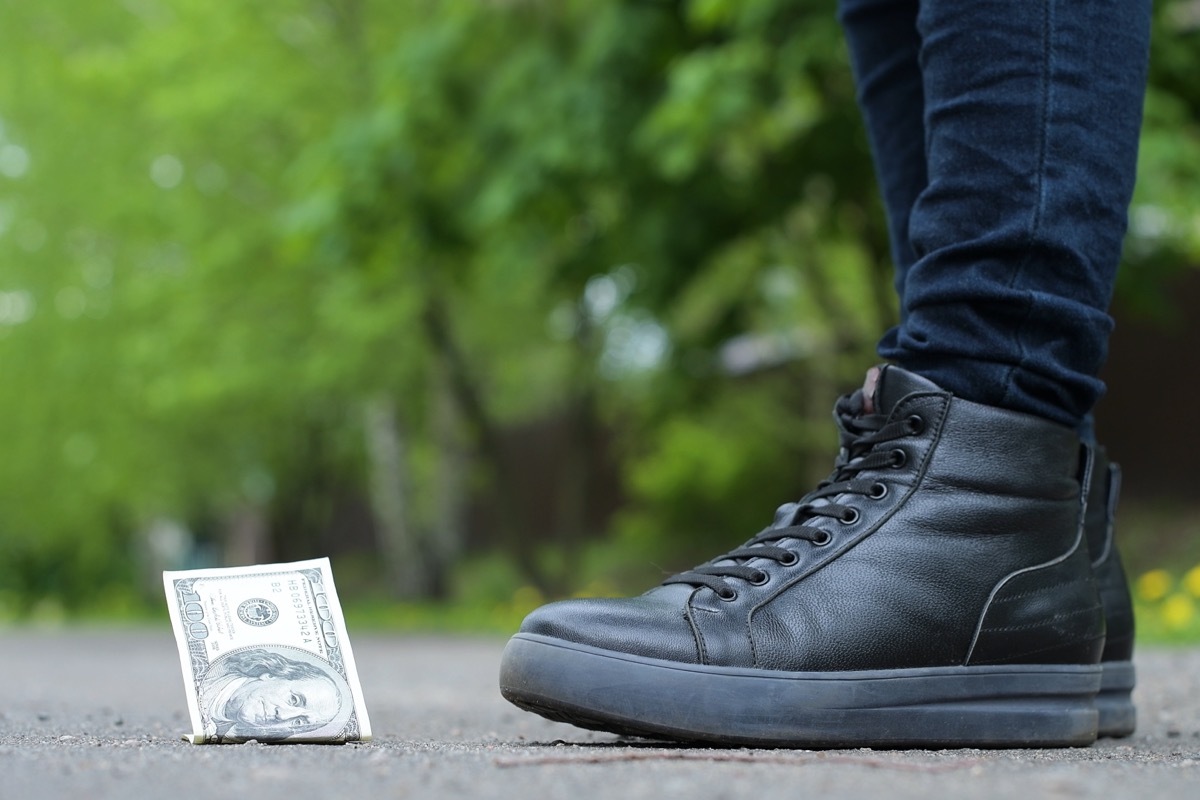 girl finding dollar in street