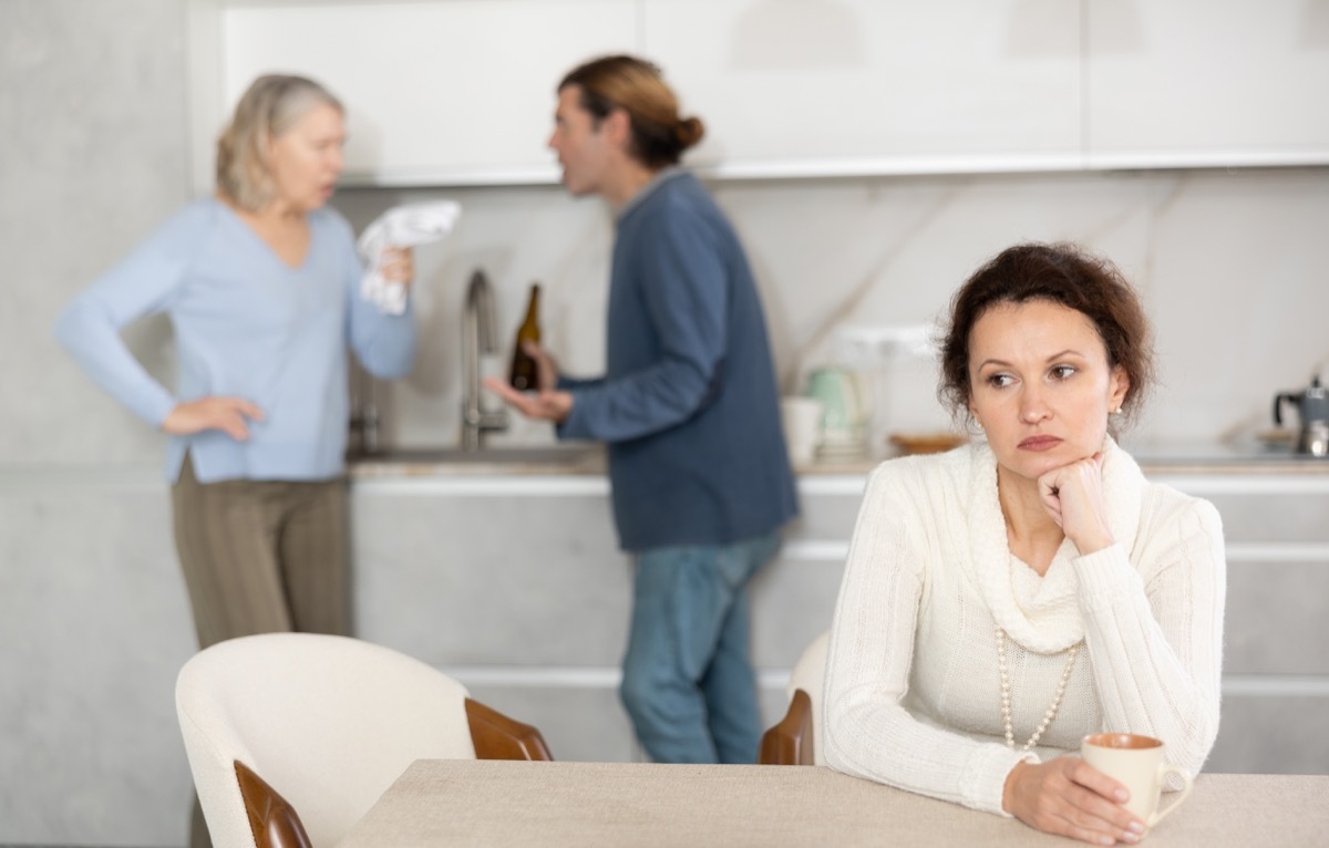 Distressed woman is present during quarrel between her husband and elderly female mom. Mature woman and son-in-law swear and insult each other