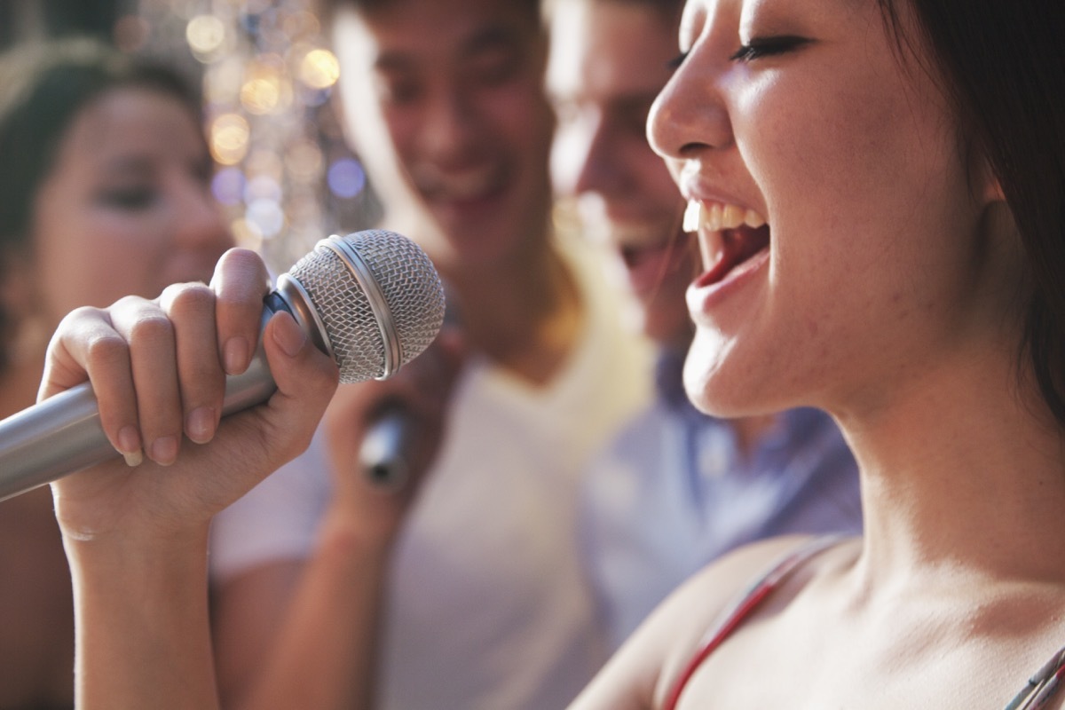 group of young friends singing karaoke