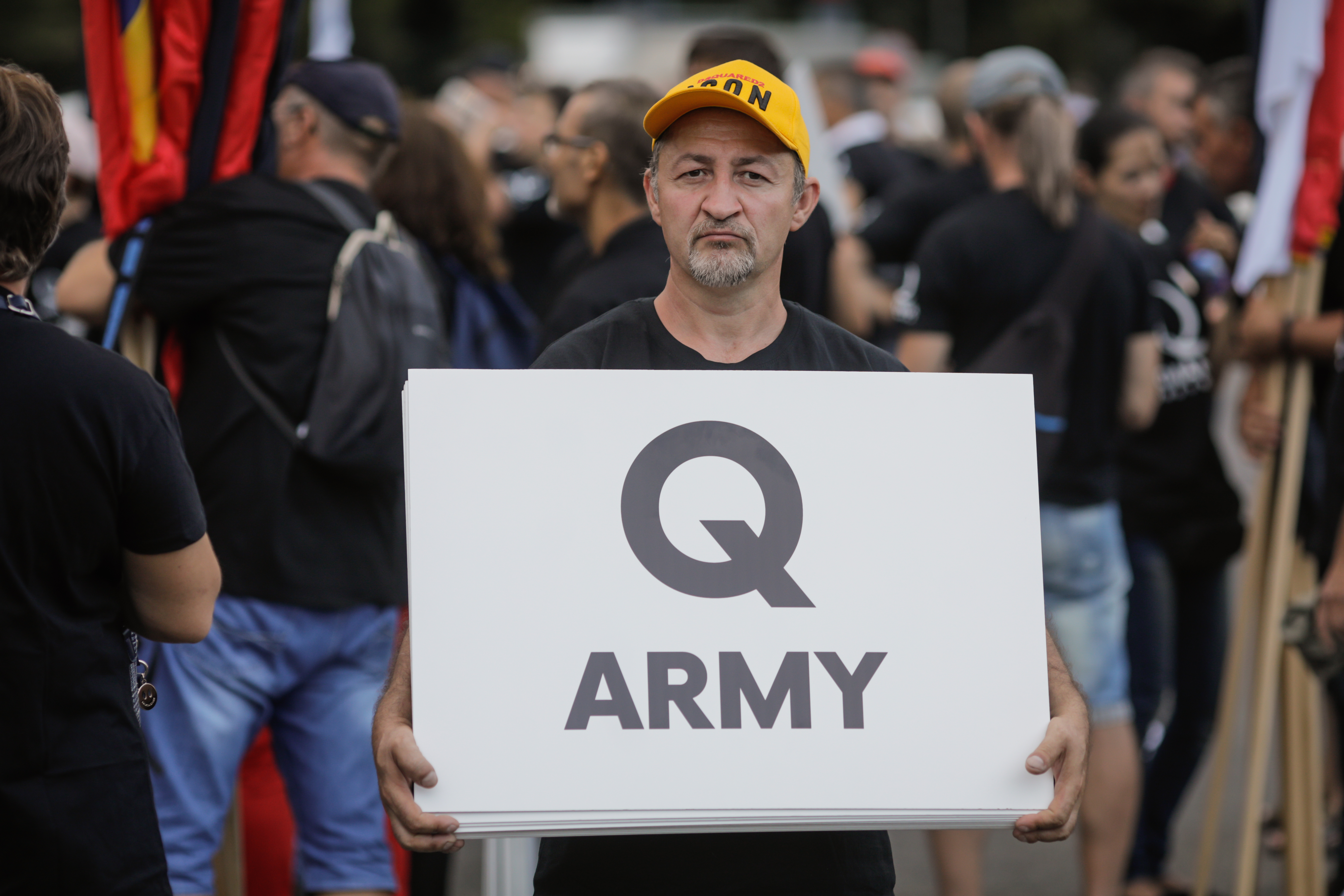 Man holding Qanon sign.