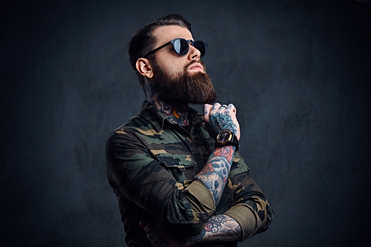 tattooed bearded hipster posing