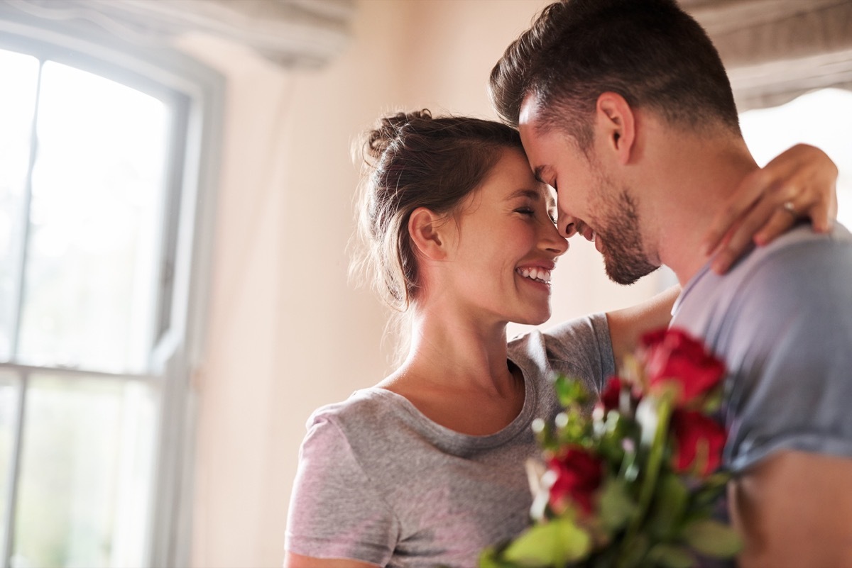 relationship quotes - smiling couple in love with red roses