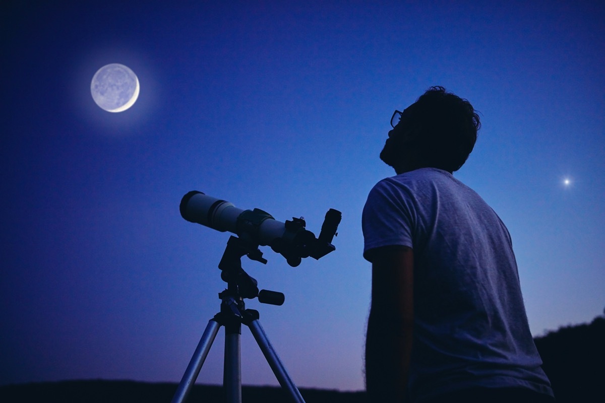 Man looking at moon with telescope