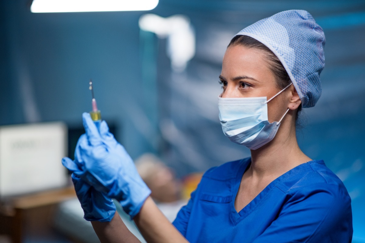 Doctor holding syringe in hospital.