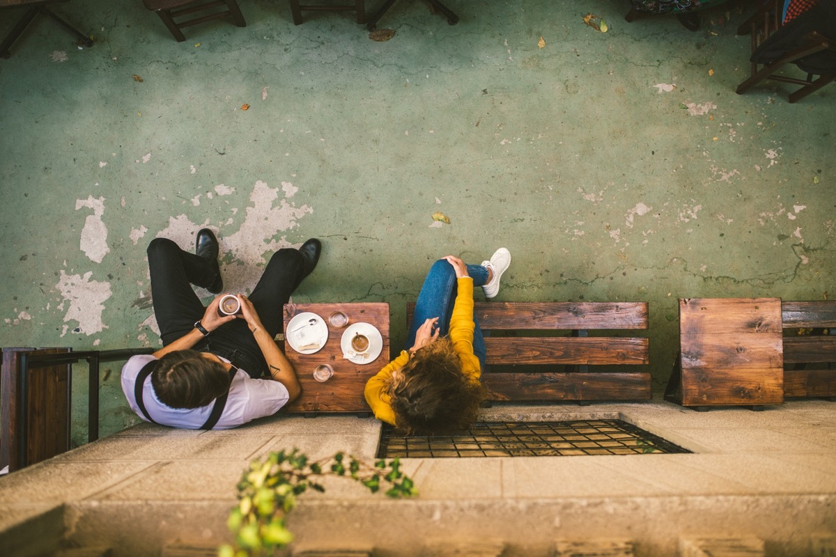 overhead view of two young people talking outside a coffee shop