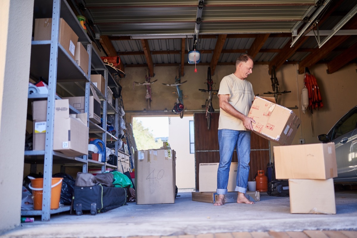 Shot of a man carrying a box in a garage