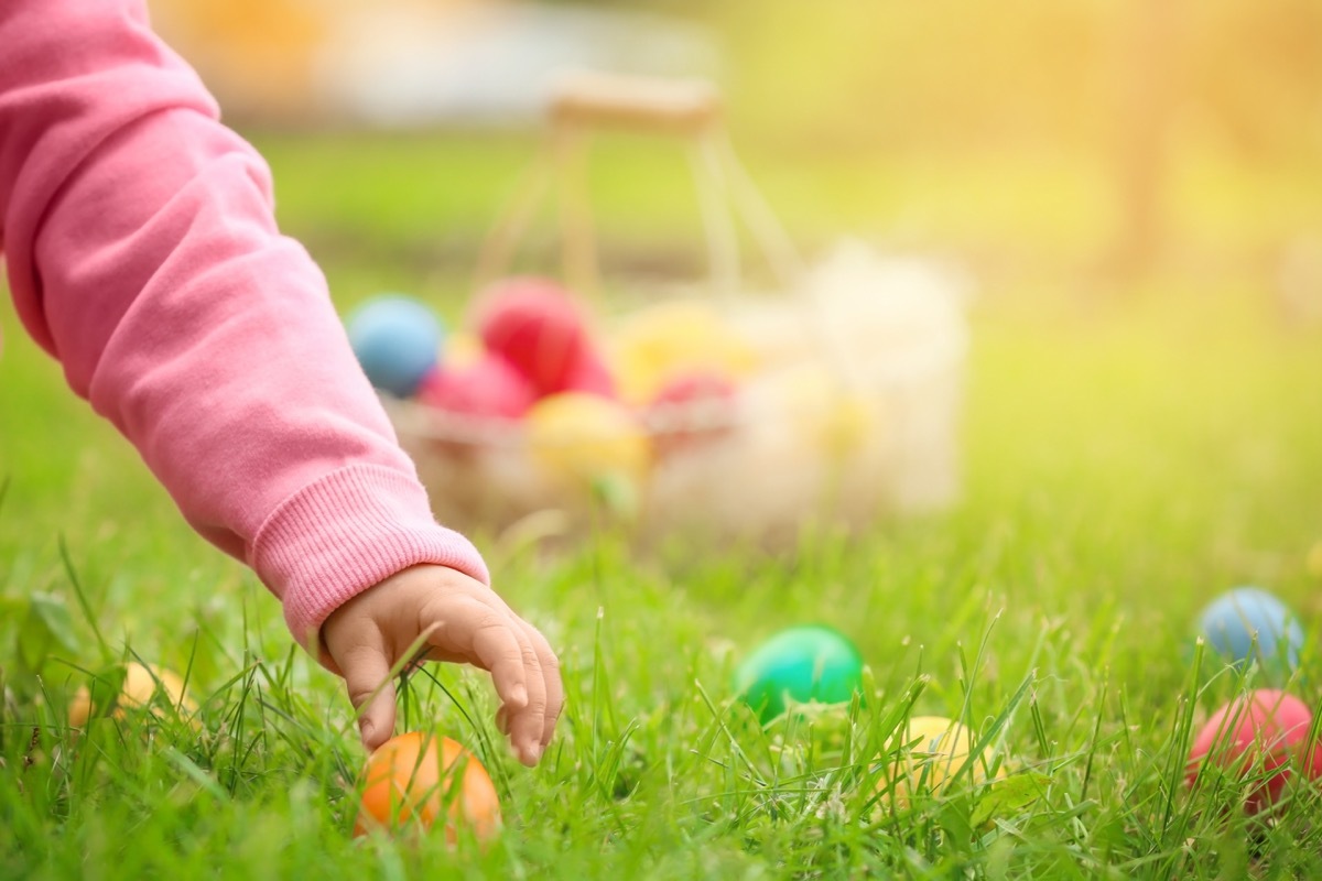 child's hand grabbing easter egg, boiled eggs