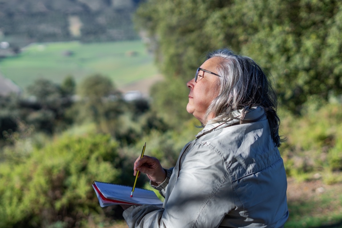 mature woman journaling outside