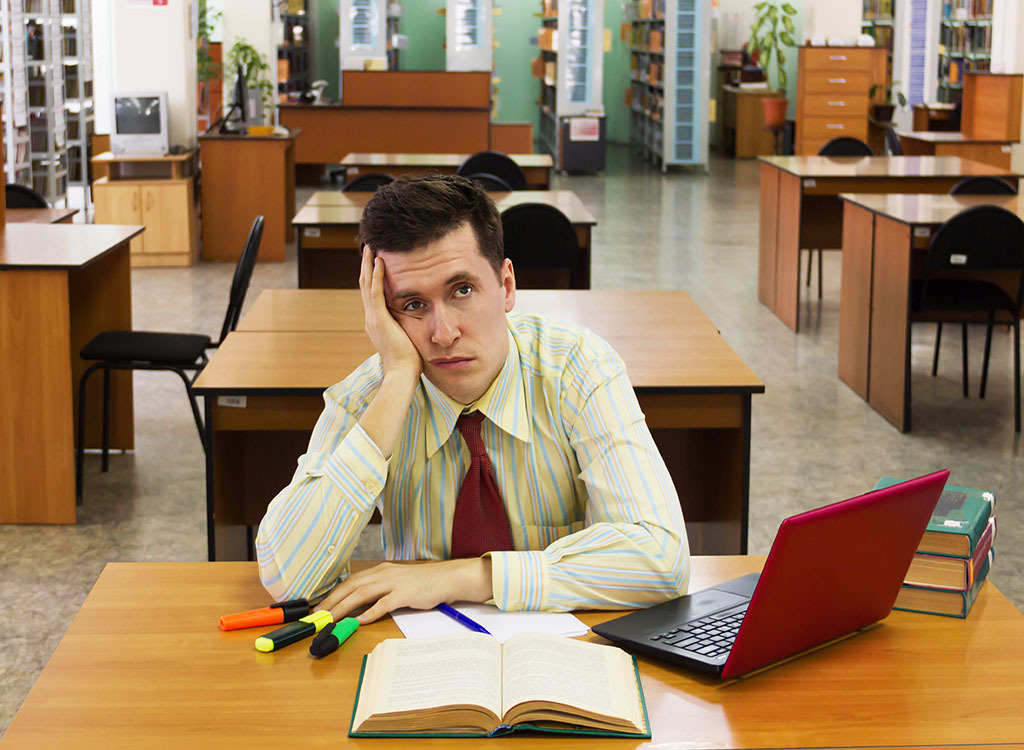 Bored man reading book college professor secrets