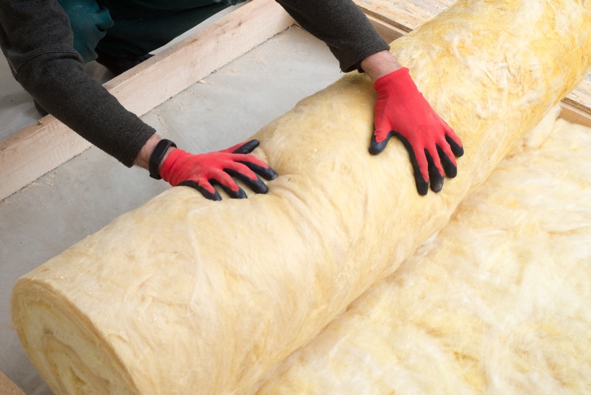 Construction Worker with Roll of Insulating Material, Floor Insulating by Mineral Wool