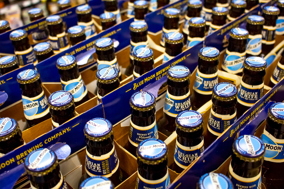 A background full of Blue Moon bottled beer on a shelf at the grocery store