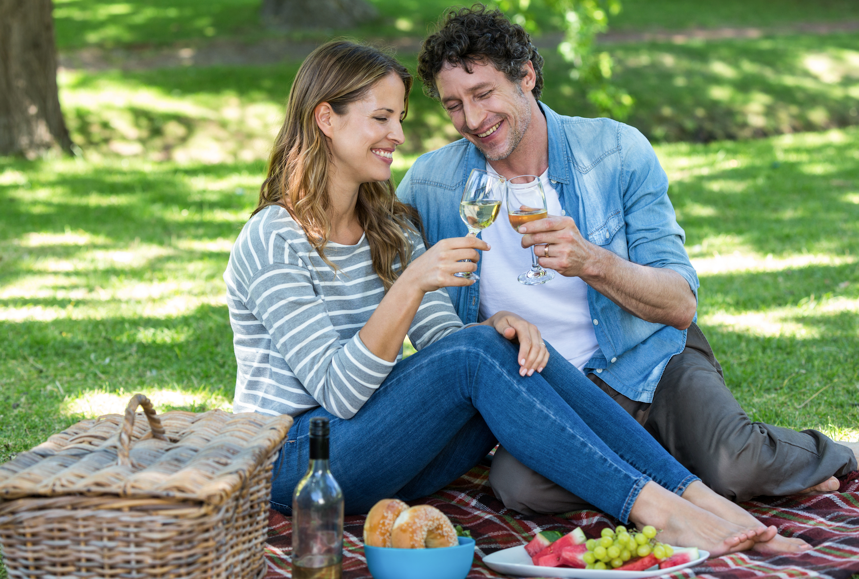 Man and woman having romantic park picnic date