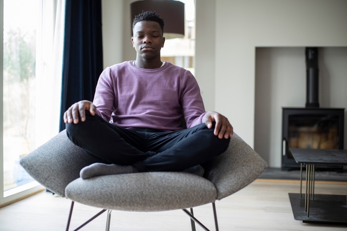 Young man meditating in a chair