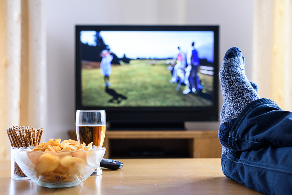 man watching tv with feet up