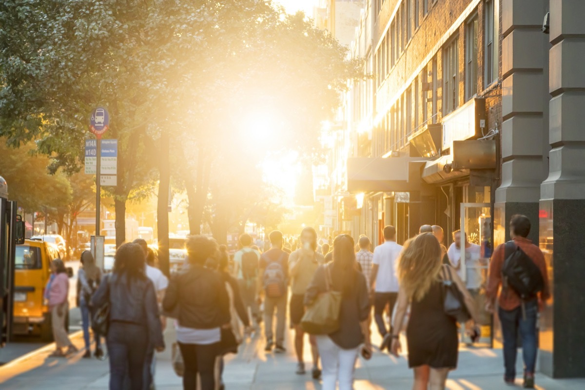 Crowded New York City sidewalk at sunset