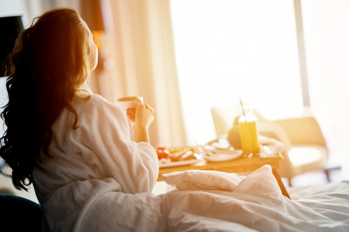 a bougie woman eating breakfast in bed