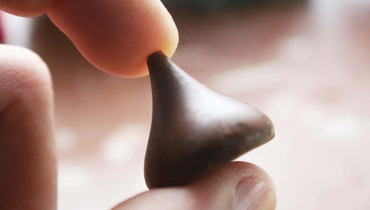 a hand holding a hersheys kiss