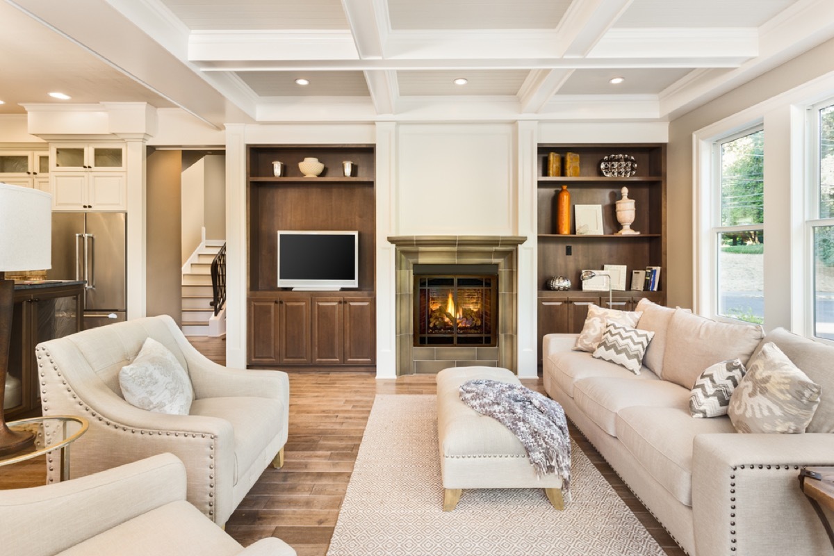 white couches and chairs facing each other in living room with fireplace