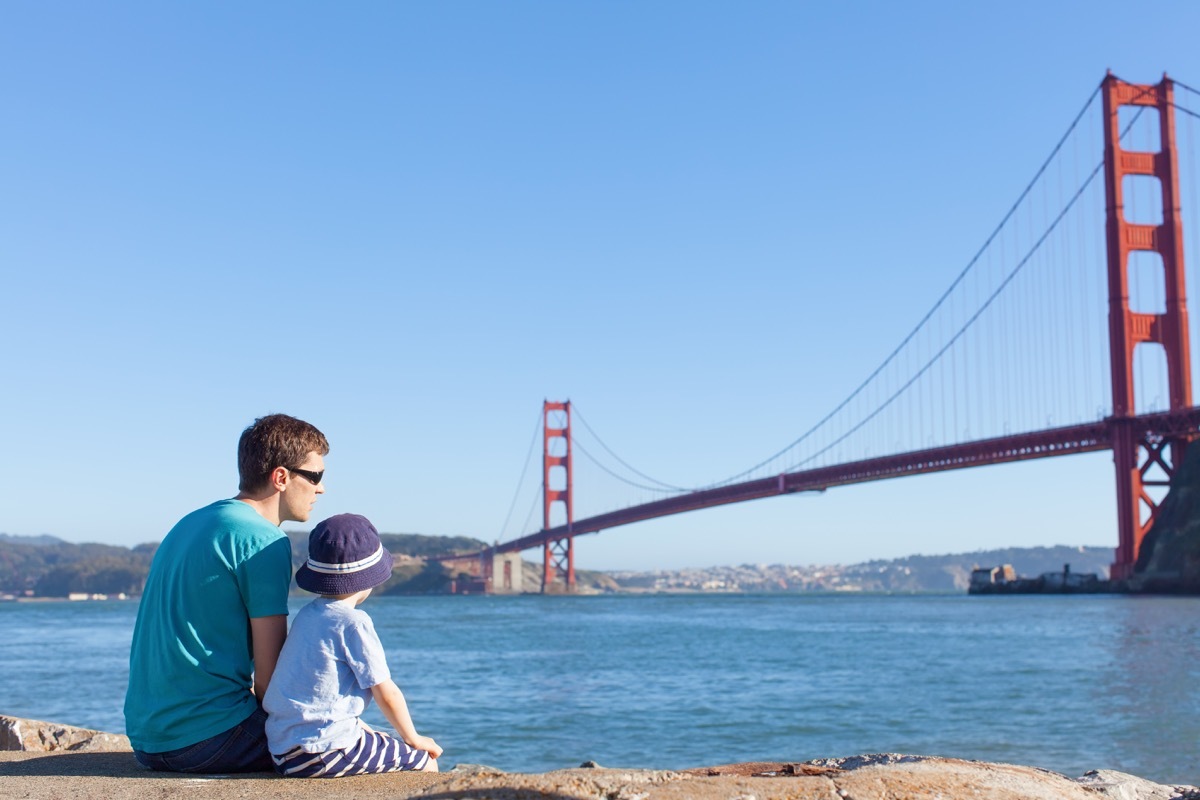 Father and son sitting and looking at the Golden Gate Bridge