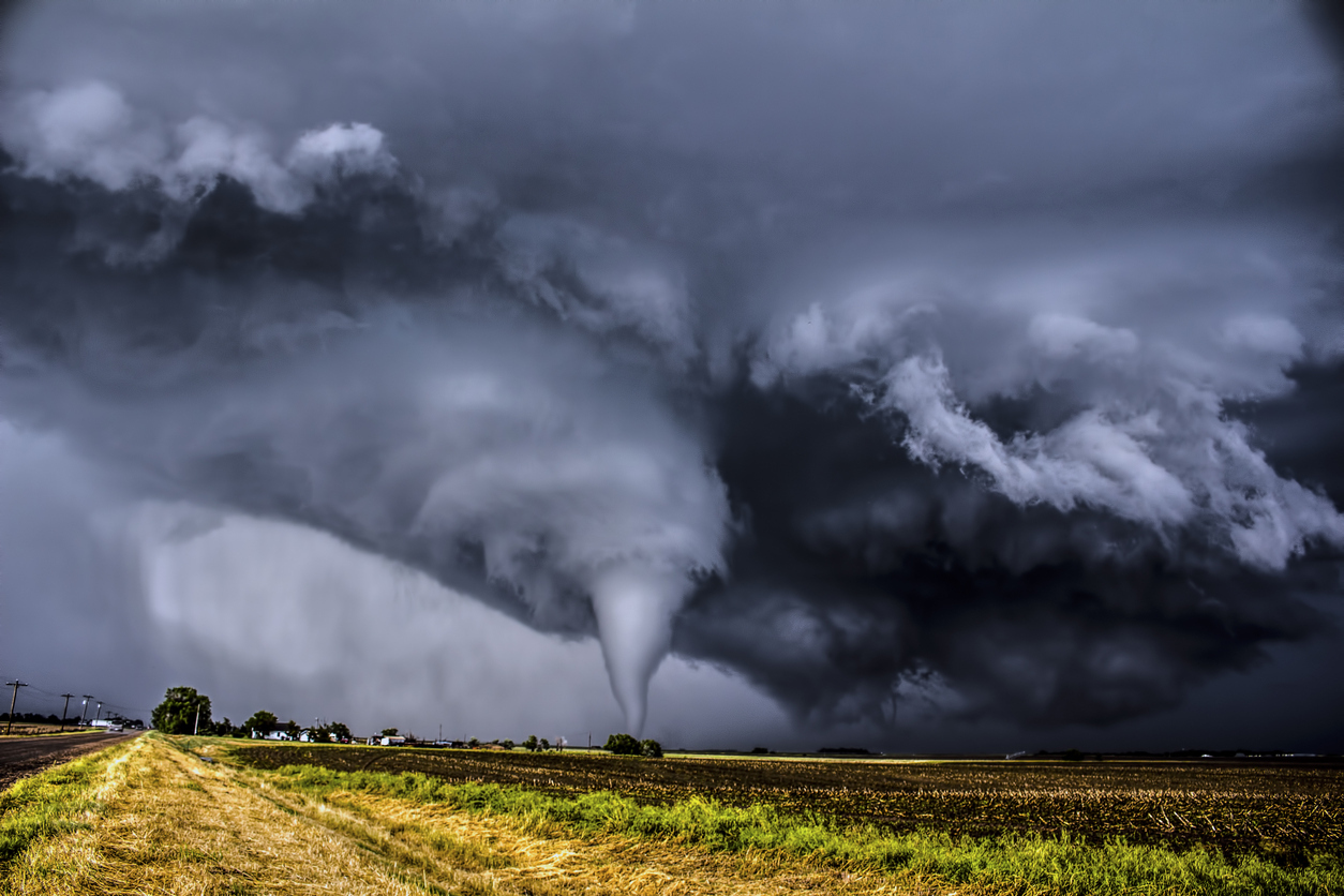 A tornado in a field surrounded by dark clouds