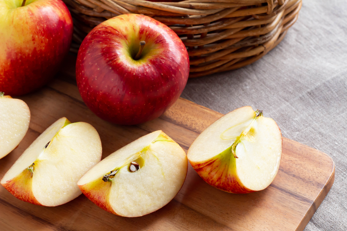 Red ripe apples and cut apples on the cutting board