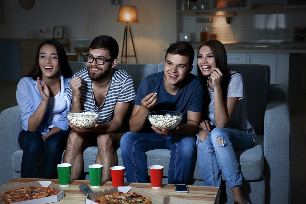 best friends watching movies on the couch and eating popcorn