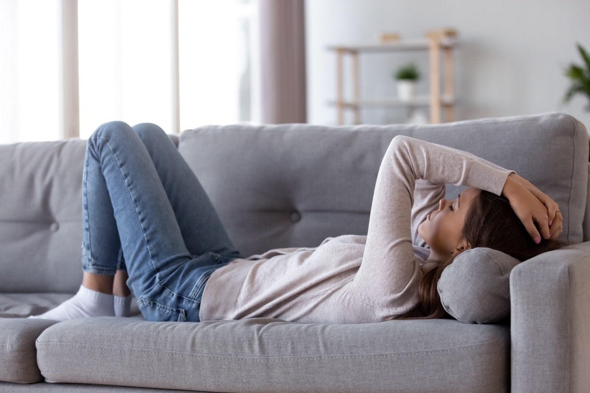 woman laying in bed with migraine