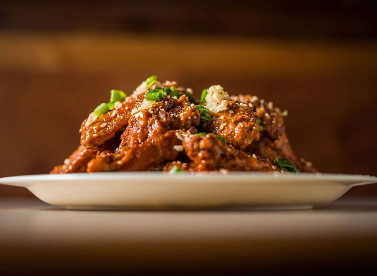 platter of chicken wings topped with scallions