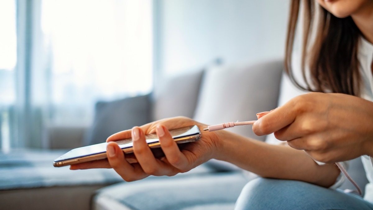 young woman charging phone