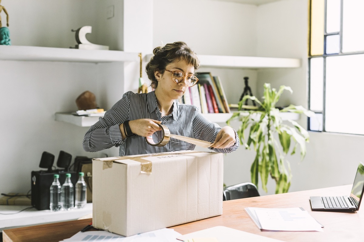 Young freelance woman sending a package to client.