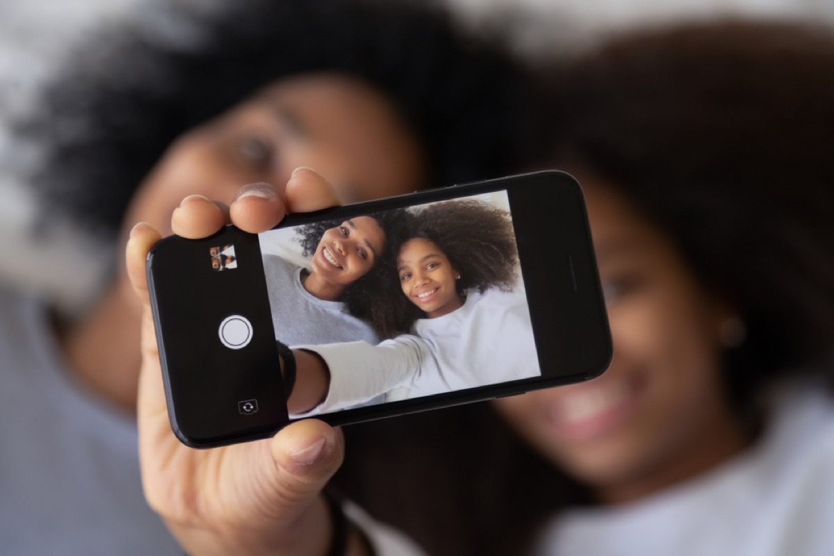 mom and daughter taking photo of themselves on phone, prepare children for divorce