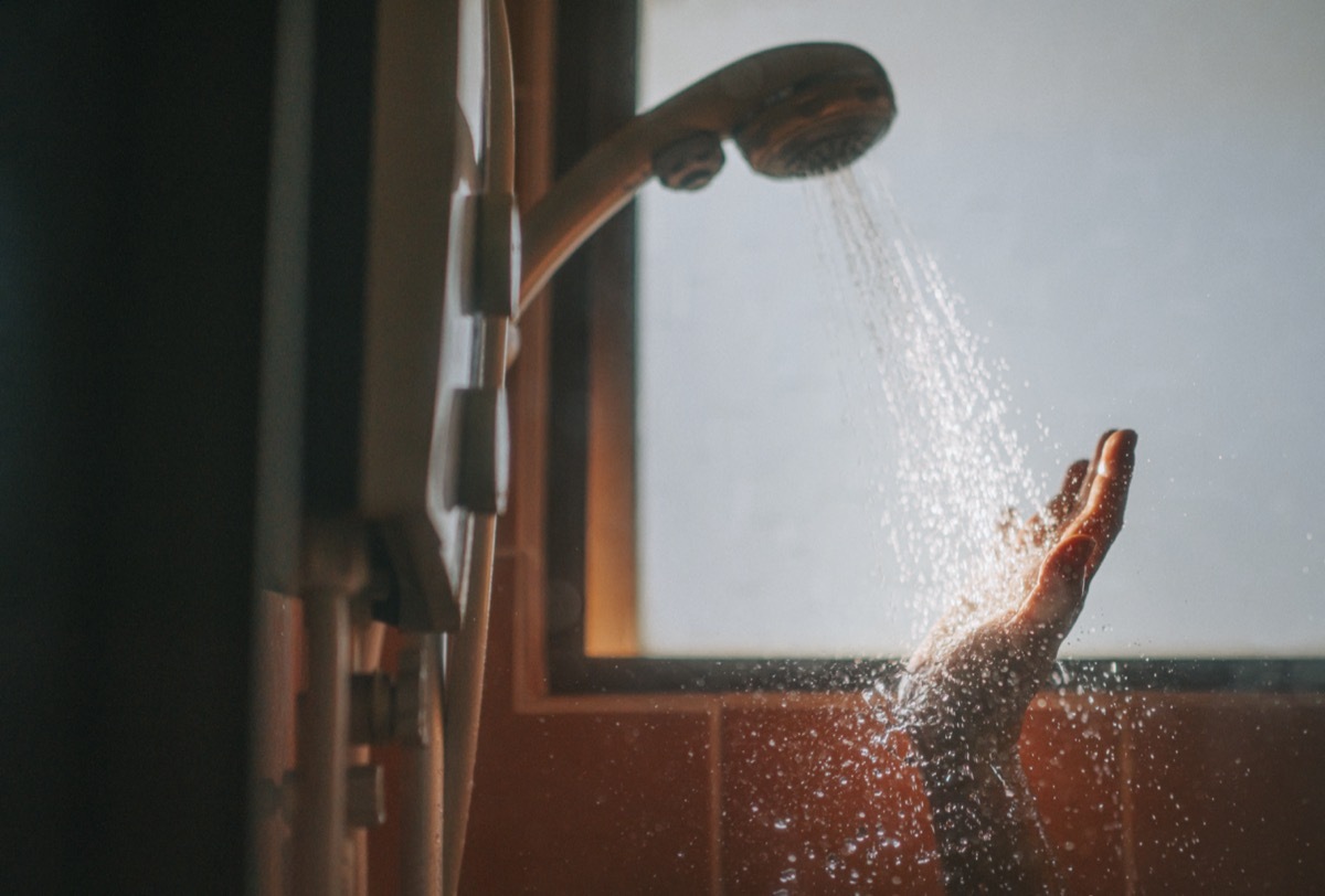 morning beginning of the day backlit sunlight bathroom female washing her hand with running water