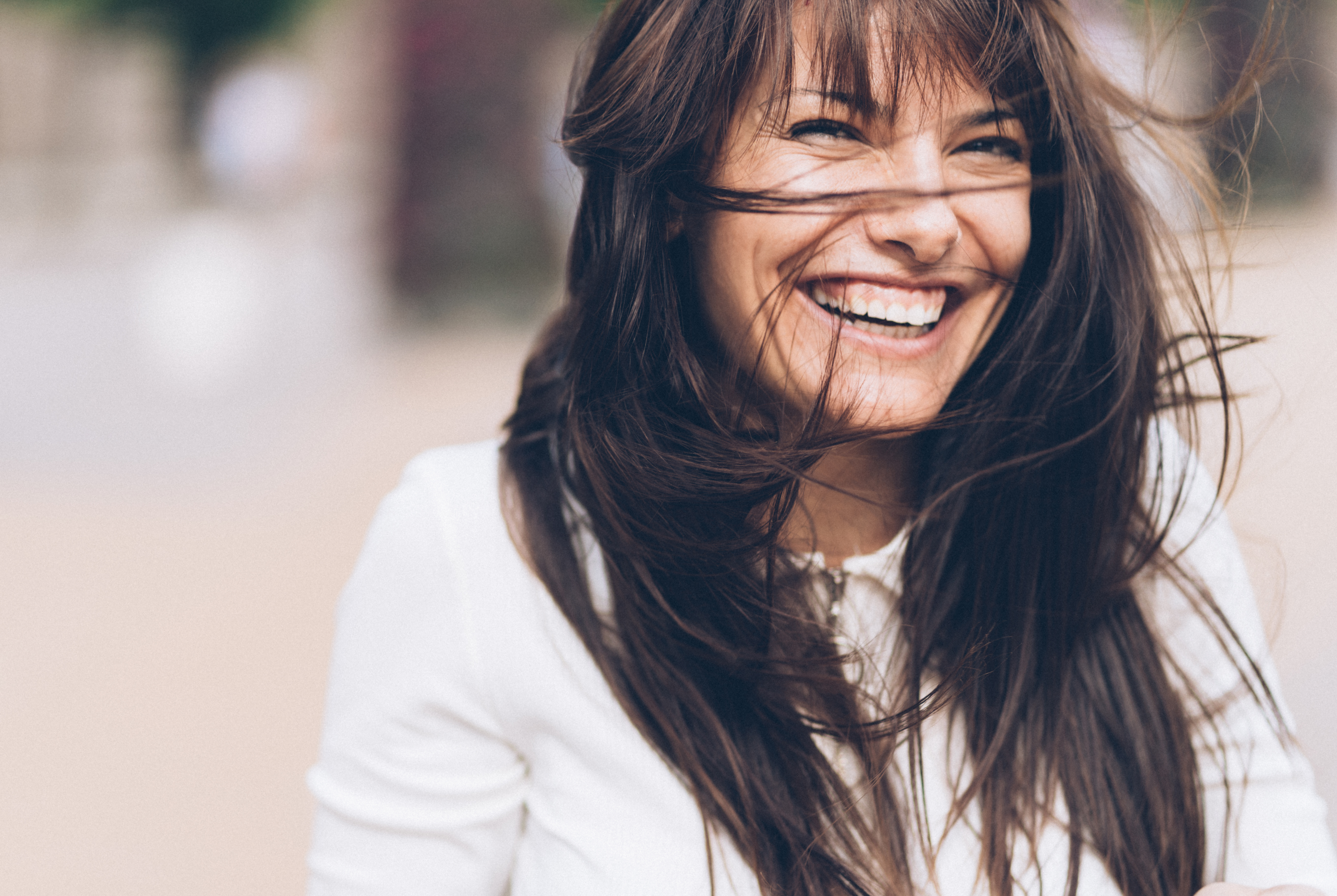 Beautiful charming woman with messy hair outdoor in windy day