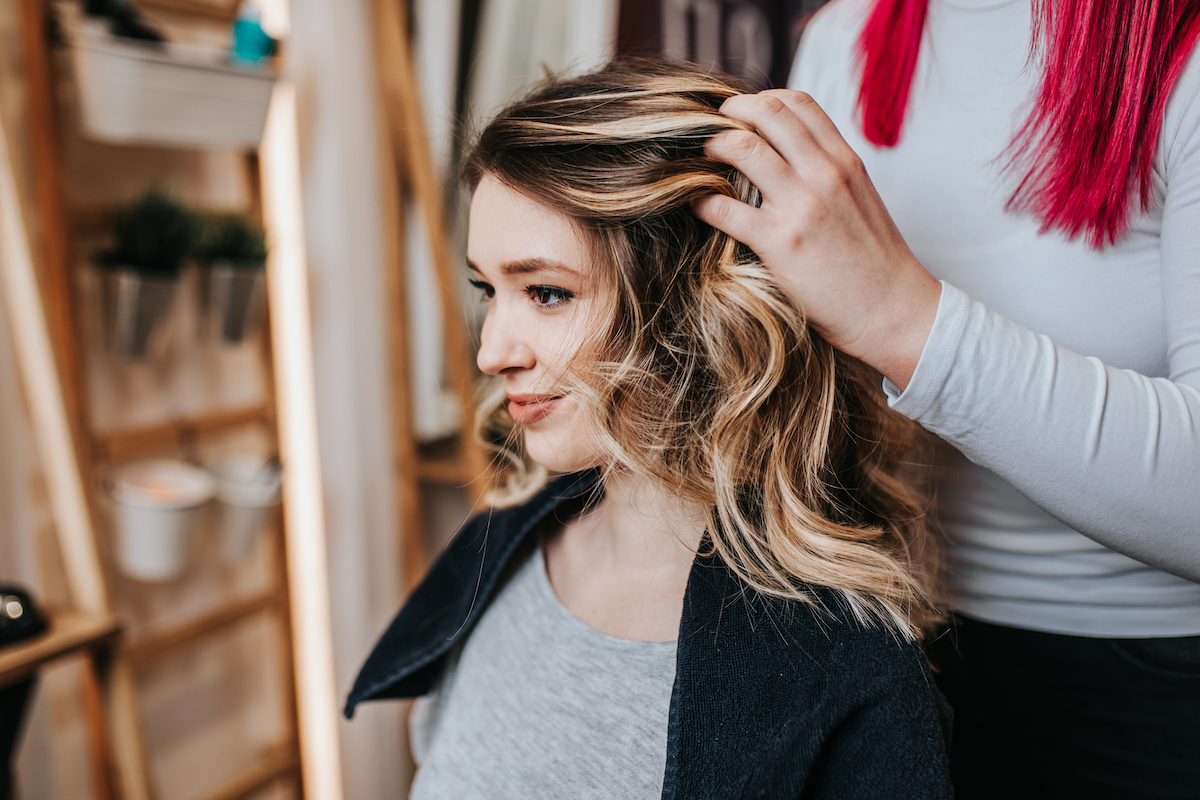 A young woman getting hair highlighted, wavy hair done at the salon.