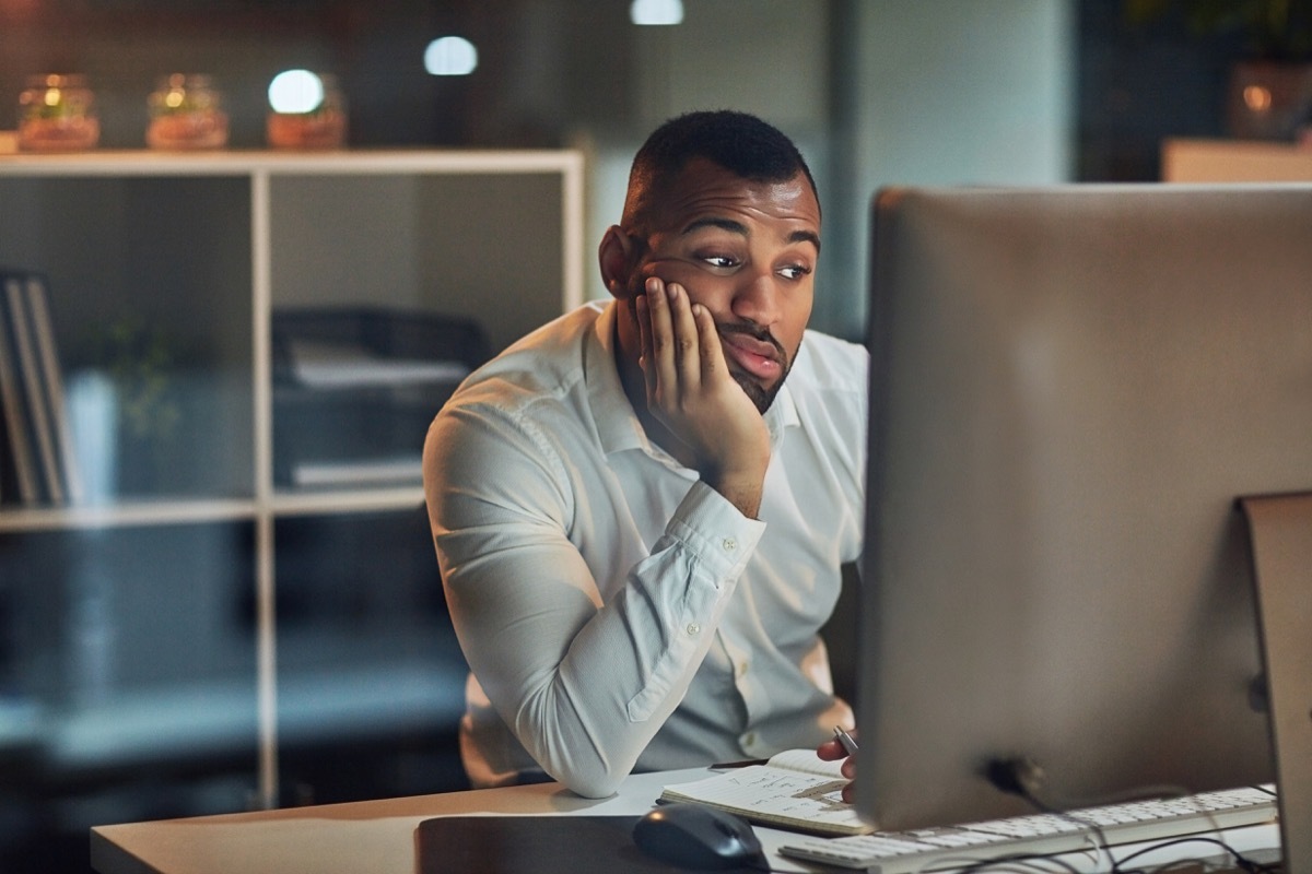 Man staring at his computer screen feeling depressed and anxious hurt mental health