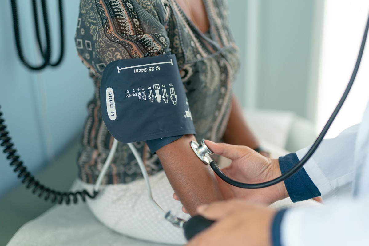 The nurse is using a blood pressure gauge to check the patient's blood pressure.