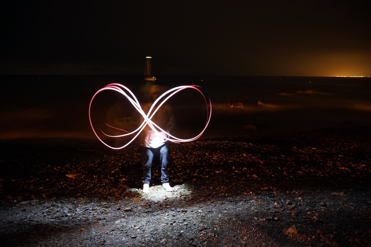 Man making an infinity sign with sparks from a sparkler