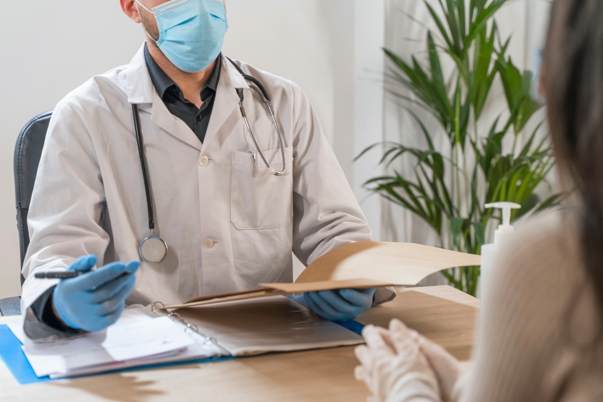 Coronavirus. Doctor visiting unhealthy woman. Doctor consults patient. They are using face mask and rubber gloves for prevention