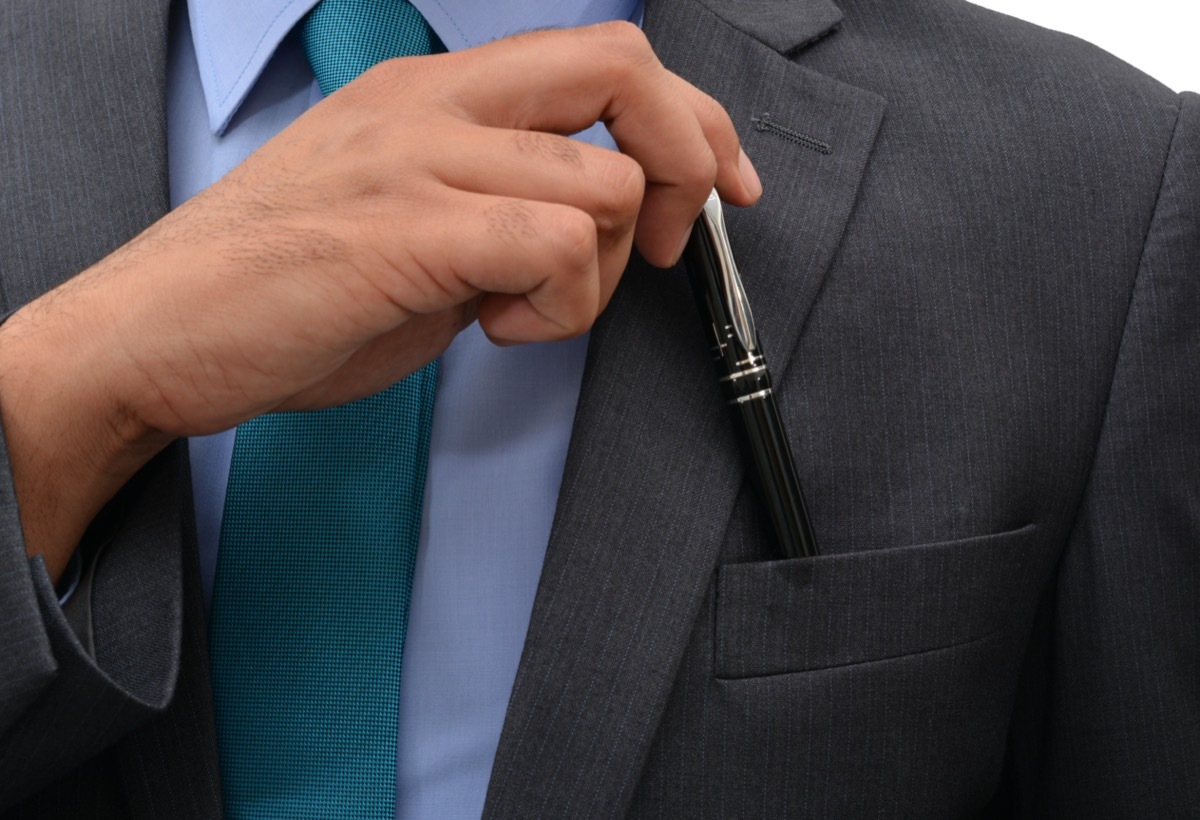 businessman putting pen in his jacket pocket