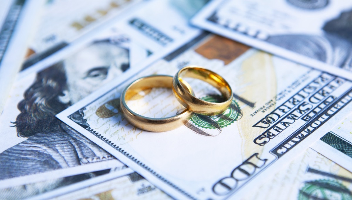 wedding rings on top of a pile of money